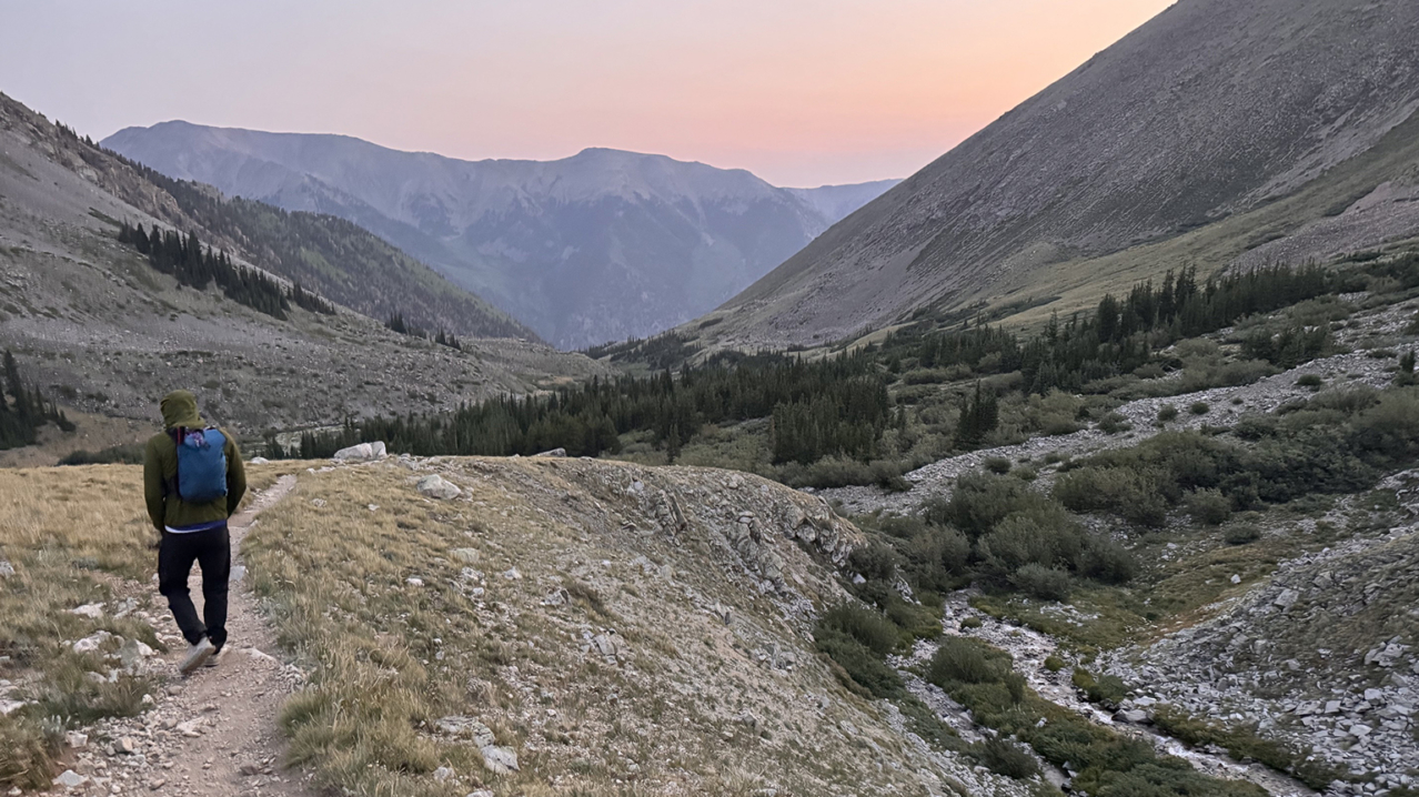 Athlete descending a mountain trail after turning back from a summit attempt, reflecting on doubt, memory, and nervous-system responses.